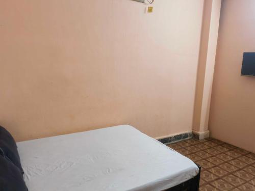 a small room with a white bed in the corner at Hotel O Hamar Mitan in Nargora
