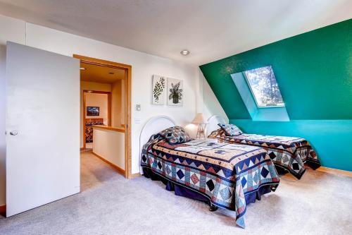 a bedroom with two beds and a green wall at Evergreen Condominiums by Keystone Resort in Keystone
