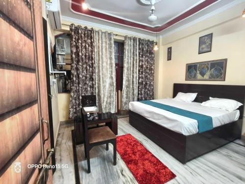 a hotel room with a bed and a red rug at HOTEL O AWARA GRAND PALACE in Pratāpgarh