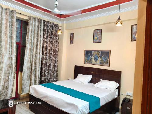 a bedroom with a bed and a window at HOTEL O AWARA GRAND PALACE in Pratāpgarh