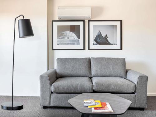 a living room with a couch and a table at Mantra on Northbourne in Canberra