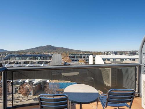 a balcony with chairs and a table and a view at Mantra on Northbourne in Canberra