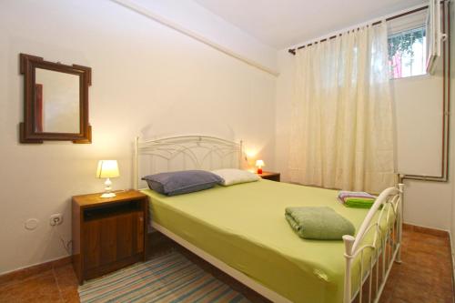 a bedroom with a green bed and a window at Apartments Kada 1571 in Pula