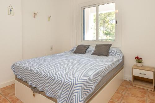 a bedroom with a large bed with a window at Bosmar 1C in Pals