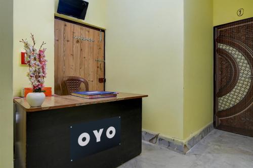 a desk with an ovo sign on it next to a door at Hotel O Lila Guest House in Sāntrāgāchi