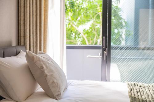 a bed with white pillows in front of a window at Shin-Imamiya Grand F in Osaka