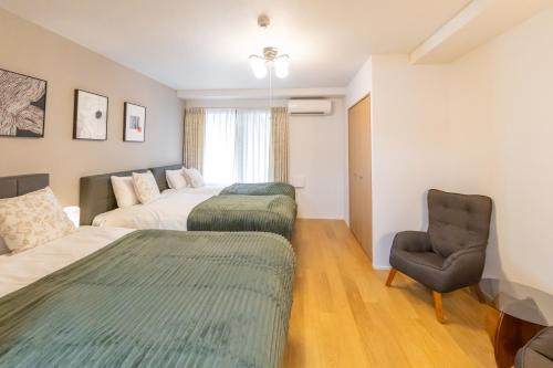 a hotel room with two beds and a chair at Shin-Imamiya Grand F in Osaka