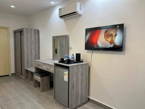 ein Zimmer mit einem Fernseher an der Wand und einer Theke in der Unterkunft The charming view in Wadi Musa