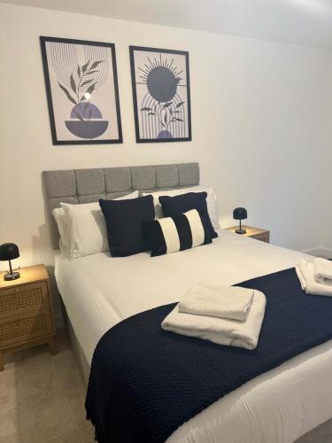 a bedroom with a large bed with towels on it at Luxury Modern 1 bed Central Bracknell in Bracknell