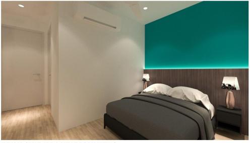 a bedroom with a bed with a green accent wall at Roomstay KOBANAS in Ipoh