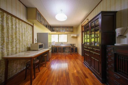 a kitchen with a wooden table and a counter top at お宿竹あかりOyado Takeakari in Takachiho