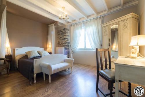 a bedroom with a bed and a chair and a desk at La demeure de zoé in Castelbiague
