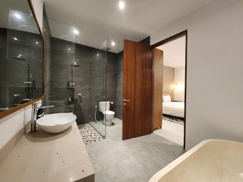 une salle de bain avec une baignoire, un lavabo et des toilettes dans l'établissement Sagrada Villa canggu Bali, à Dalung