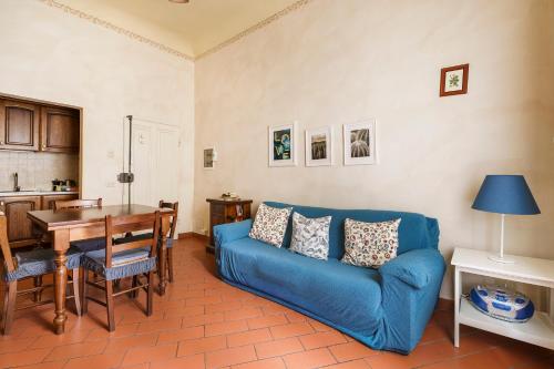 a living room with a blue couch and a table at Inferno Double in Florence