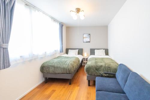 a living room with two beds and a couch at Shin-Imamiya Grand F in Osaka