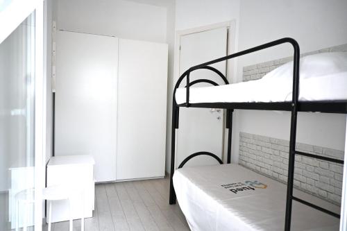 a room with two bunk beds and a window at M272 - Marcelli, trilocale con giardino e posto auto in Marcelli
