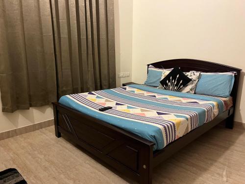 a bedroom with a bed with a wooden frame at Luxe Loop in Mahabalipuram