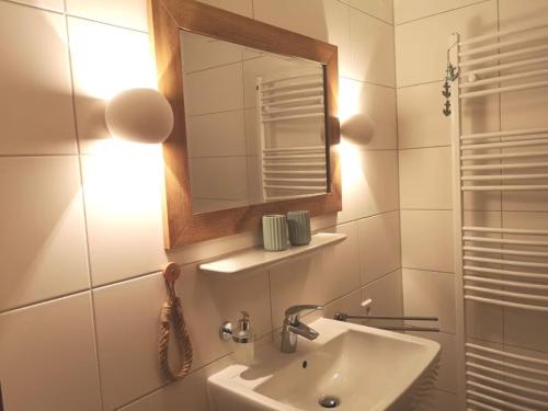 a bathroom with a sink and a mirror at Ferienwohnung Boven in Timmel