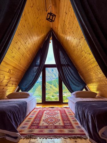 Gorists'ikheKvirike Cottage的一间有大窗户的房间里有两张床