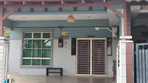 a white building with a door and windows at D Aida Homestay in Kampong Bukit Katil