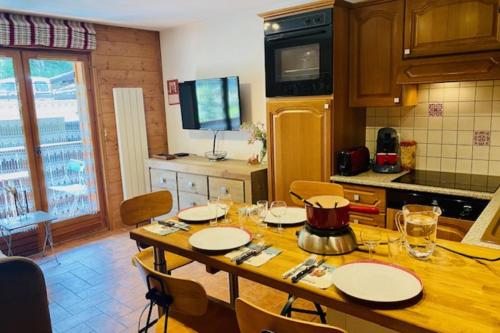 cocina con mesa de madera y sillas en Slopes Of Les Houches 25 M With Balcony, en Les Houches