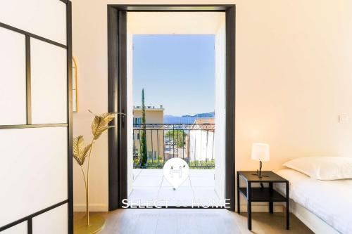 a bedroom with a door leading to a balcony at SELECT'soHOME - Villa pour 8 personnes avec jacuzzi, vue mer et parking au coeur du Lavandou ! - VILLA MOUN PANTAI in Le Lavandou