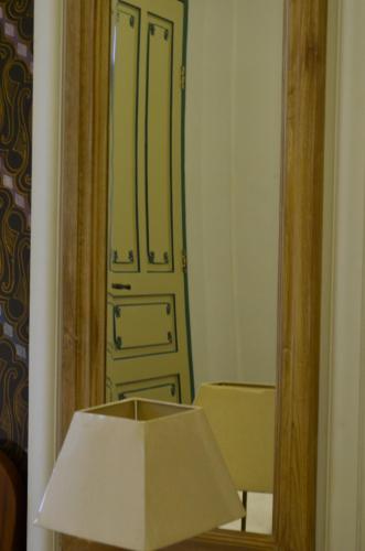 Habitación con puerta, lámpara y espejo. en Rumah Jawa Guest House (Syariah), en Yogyakarta