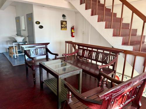 a living room with two benches and a staircase at Dengba Hostel - Loikroh Chiangmai in Ban Hua Phrong