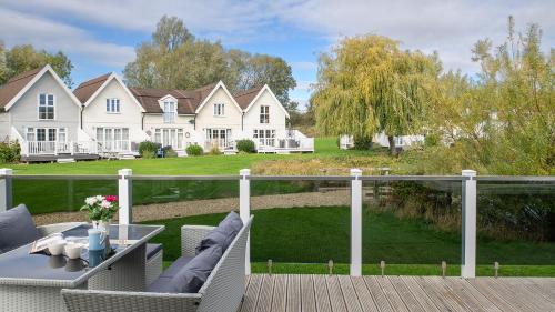 a deck with a table and chairs and a house at Venture Lakeside Lodge in South Cerney