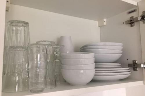 a shelf with plates and bowls and other dishes at Ideally located studio Foch & Parc de la Tête d’Or in Gare des Brotteaux