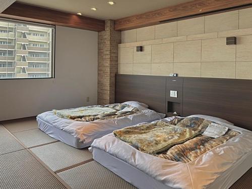 two beds sitting in a room with at DOMO Hotel 大津 in Ozu