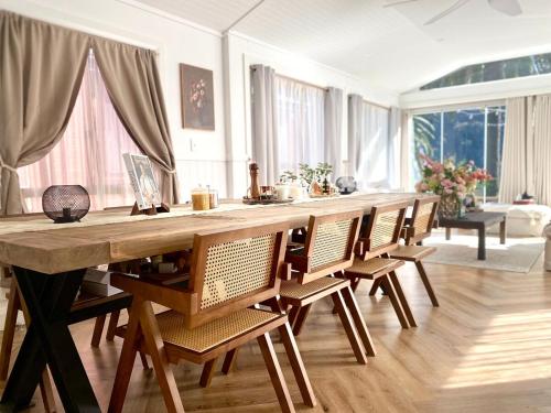 ワイズマンズ・フェリーにあるGlasshouse On The Water PET FRIENDLYの大きな木製テーブル(椅子付)