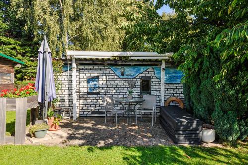 a small shed with a table and chairs and an umbrella at Ferienwohnung KonradAlbrecht in Torgelow am See