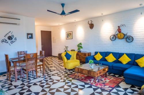 Una sala de estar con un sofá azul y una mesa. en Casa Magnolia by Da Alohas, en Nerul