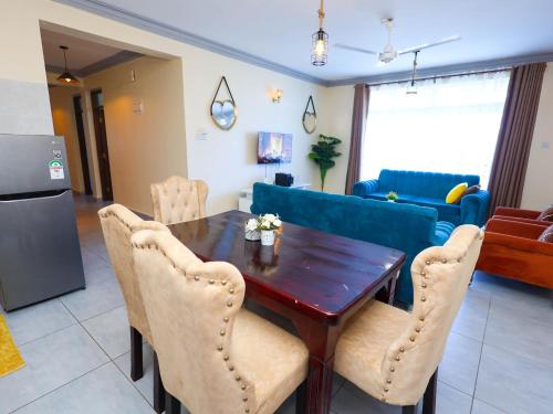 モンバサにあるCozy apartment near the beachの木製のテーブルと椅子のあるキッチンとリビングルーム