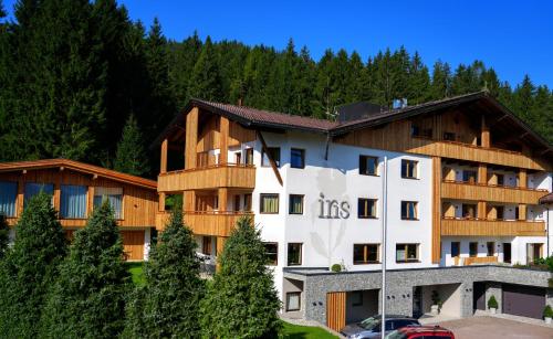a hotel in the mountains with trees in the background at Aparthotel Iris - inklusive Wildschönau Premium Card in Auffach