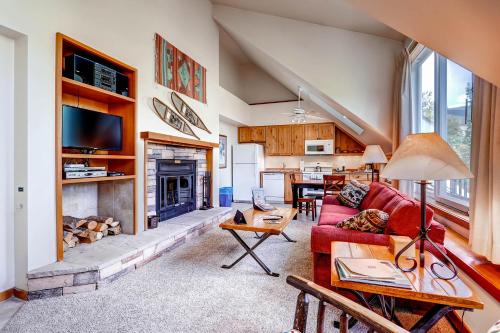 a living room with a red couch and a fireplace at Evergreen Condominiums by Keystone Resort in Keystone