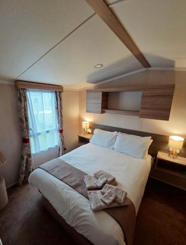 a bedroom with a large bed with towels on it at Holiday Home at Hoburne Naish in Barton on Sea