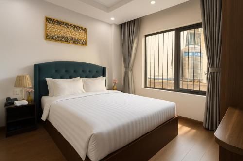 a bedroom with a large bed and a window at Splendid Star Boutique Hotel in Hanoi