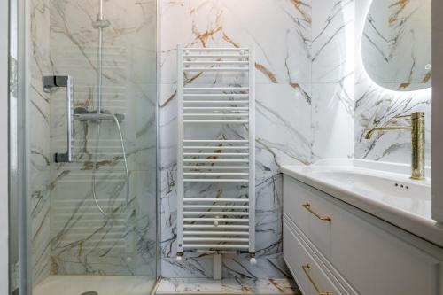 ein weißes Badezimmer mit Dusche und Waschbecken in der Unterkunft L'Elbe in Serris