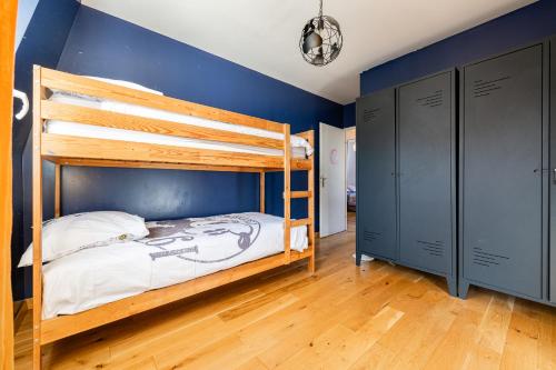 ein Schlafzimmer mit einem Etagenbett und einer blauen Wand in der Unterkunft L'Elbe in Serris