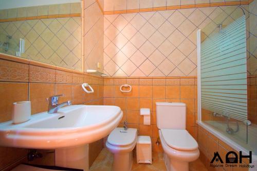 a bathroom with a sink and a toilet and a mirror at Luz do Sol in Guia