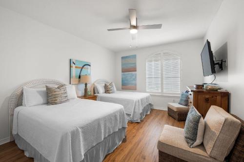 a white room with two beds and a chair at Charter Landing A7 in Orange Beach