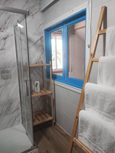 a bathroom with a glass shower door next to a window at CASA DO AVÒ in Castrelo de Miño