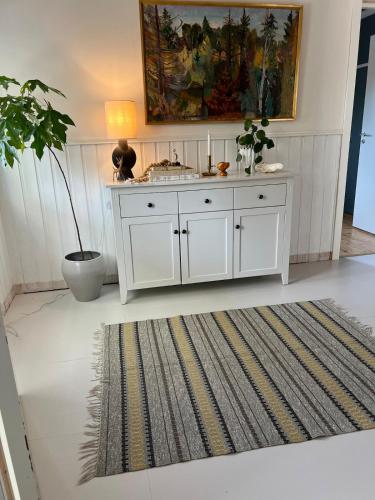 a white cabinet in a room with a rug at Särna, Cozy and Central in Särna
