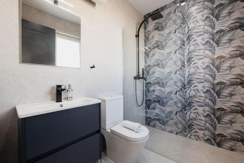 a bathroom with a toilet and a shower curtain at Ph Jacuzzi &stunningterrace Near Tarxien Temples in Tarxien