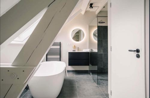 a bathroom with a white tub and a sink at Xxl Loft City Center Villa Tilburg Willem 2 in Tilburg