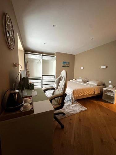 a bedroom with a bed and a chair and a desk at Charmant manoir rénové avec chambres indépendantes et salles de bain privatives, in Domagné