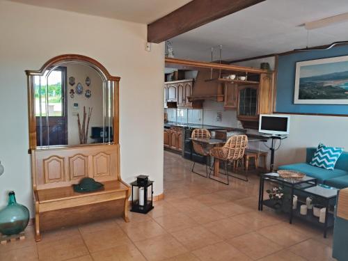 a living room and kitchen with a blue couch at Casa Corral Bouzamayor in Valdoviño