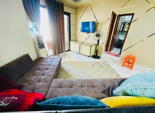 a living room with a couch and a tv at بورتو سعيد شاليهات لإيجار من المالك in Port Said